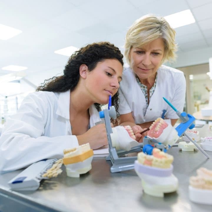 Zahntechnikerinnen beim fachlichen Austausch auf der Arbeit