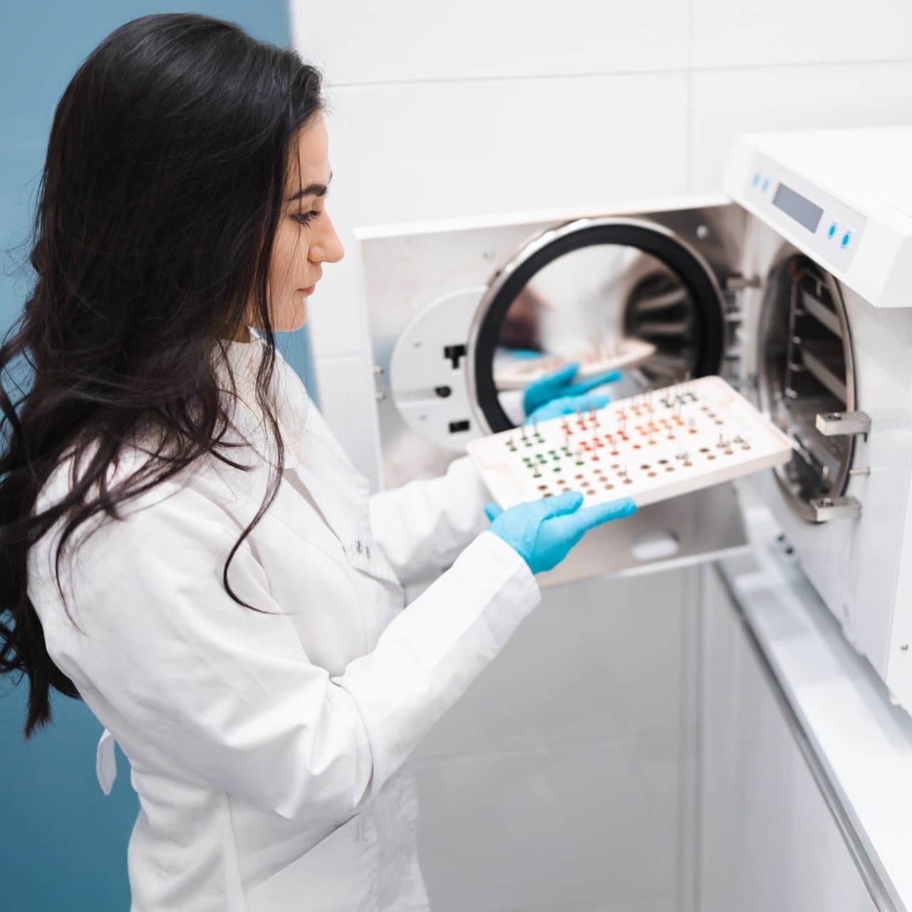 Zahntechnikerin an zahntechischem Gerät