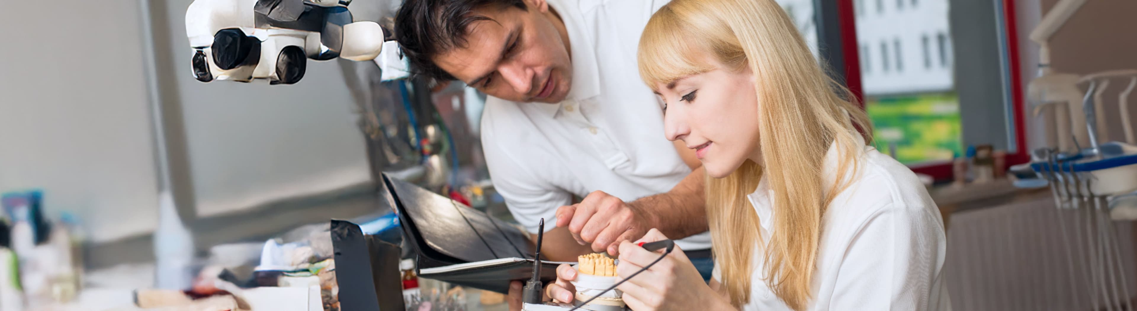 Zahntechnikerin und ihr Chef bei der Arbeit